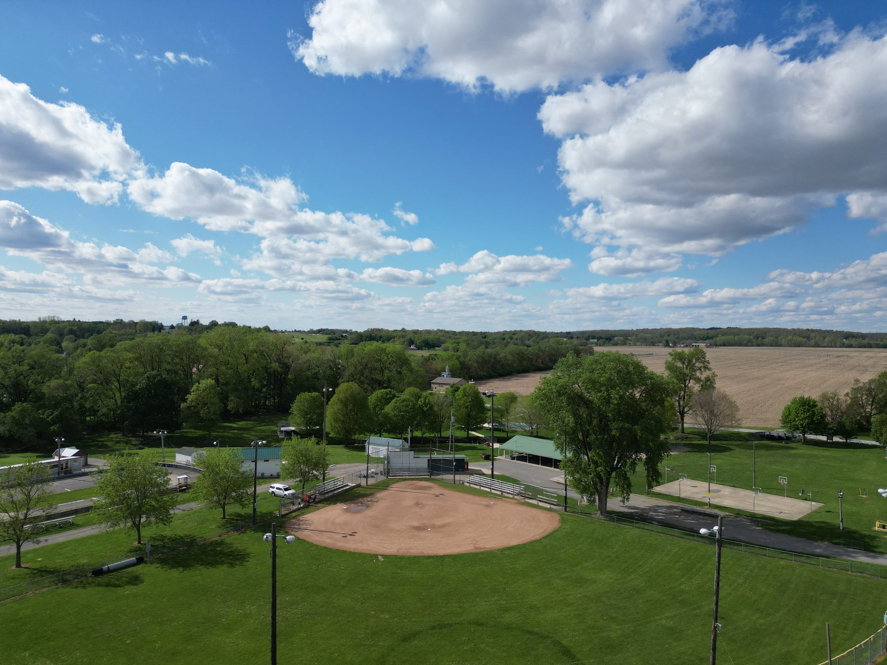 A ball diamond at Lions Club Community Park with its backstop, bleachers, light poles and open outfield